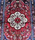 Close-up of a red floral patterned with intricate design Persian rug