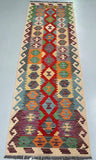 Colorful patterned Afghan Kilim Runner with geometric design on a plain background