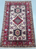 Decorative Kazak rug with Caucasian patterns on a beige background
