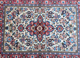 Decorative Persian rug with intricate floral patterns in red, blue, and beige.