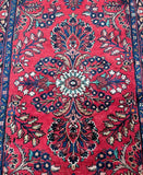 Close-up of a red patterned handmade Persian hall runner rug with intricate designs