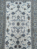 A fine Persian Kashan rug with a beige and blue floral pattern on a white background, featuring a cotton base and pure lamb's wool pile.