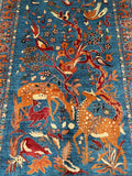 Decorative rug with deer, birds, and floral patterns on a blue background