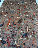 handmade rug with various animals and plants on a llight brown background.