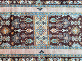 A detailed shot of a traditional Afghan Chobi hall runner rug with a floral design in various colors including brown, turquoise, orange, yellow, and beige, featuring a geometric pattern.