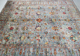 Large ornate Chobi rug with intricate patterns on a plain background