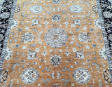 A close-up view of a handcrafted Afghan Chobi rug featuring a floral geometric pattern with dark caramel, beige, and black tones.
