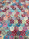 A multicolored, geometric-patterned woolen Moroccan rug with a pile texture.