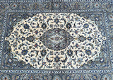 A round, floral patterned Persian Kashan rug with a central medallion design, featuring beige, blue, brown, and green tones.