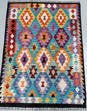 Colorful geometric patterned rug with vibrant colors on a plain background