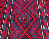 A vibrant, multicolored tribal Afghan kilim rug 4.5x2.9m featuring a geometric pattern with red, blue, orange, and black hues.