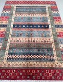 Multicolored Gabbeh patterned rug with geometric design on a plain background