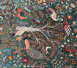 Colorful Persian rug with birds, flowers, and branches on a dark green background