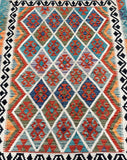 Colorful geometric Afghan Kilim rug with a diamond design.