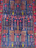 A hand-knotted Persian rug with a dense wool pile on a cotton base, featuring a Tree of Life inspired floral design in various colors.