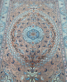A traditional hand-knotted Persian rug with a floral pattern in multiple colors, including caramel, blue, and brown.