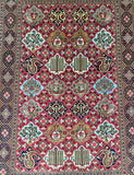 A traditional Persian Qum rug 200x150cm area rug with a complex geometric and floral pattern. The dominant color is a rich red, accented by beige, navy blue, light blue, and gold motifs arranged in a symmetrical grid.