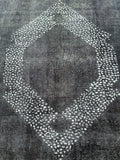 Overdyed Persian Tabriz rug with a central medallion design featuring a geometric pattern in a charcoal and grey tone on a dark background.