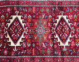 A vibrant, multicolored Persian Heriz hall runner rug with geometric patterns and a rich pile.