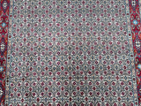 A traditional handmade Persian Birjand rug with a geometric Herati design in beige, blue, brown, red, and orange tones.