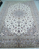 A large traditional Persian Kashan area rug 370x250cm with an intricate floral and geometric pattern, featuring a cream center field, beige and gray borders, and small accents of blue, green, and red.