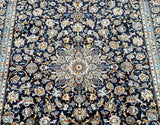 A detailed image of a traditional Persian Kashan rug with a central medallion floral design, featuring colors indigo blue, beige, aqua, and gold tones.