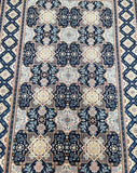 A close-up of a traditional Persian Kashan rug with a semi-geometric and semi-floral design featuring multiple colors such as blue, beige, yellow, brown, and French blue.