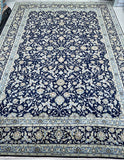 A large traditional oriental Kashan area rug with a deep navy blue field, intricate cream and beige floral motifs, and a detailed multi-colored border.