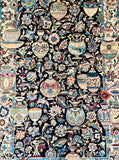 An intricate Persian Kashmar rug featuring a dense floral and geometric pattern with stylized vases and calligraphic motifs on a dark navy background.