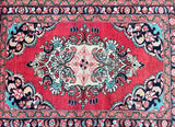 A hand-knotted Persian Lilian rug with a central medallion floral design, featuring a red, blue, beige, black, brown, and pink color palette.