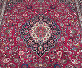 A vibrant, multicolored Persian Mashad rug with a central medallion floral design, featuring a pure lamb's wool pile on a cotton base.