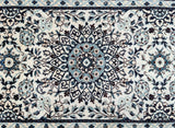 Close-up of a Persian Nain hall runner featuring a floral medallion design with beige, black, blue, brown, and burgundy tones.
