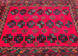 A square vintage wool Persian Quchan rug with a bright red center field, decorated with repeating geometric cross motifs in black, teal, and brown, surrounded by a detailed multicolor border.