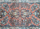 Close-up of a handmade Persian Sarough hall runner with a floral pattern in burnt orange and multiple colors.