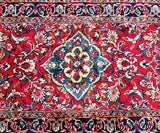 A vibrant, multicolored Persian Sarough hall runner rug with a central medallion floral design, featuring a dense lamb's wool pile on a cotton base.