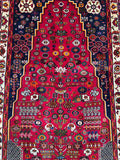 A hand-knotted Persian Shiraz Qashquli hall runner with a vase design and tree of life motif, in a variety of colors including red, blue, yellow, brown, orange, and green.