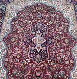 A detailed view of a Persian Tabriz rug with a central medallion and scrolling floral design in a room size of 3.4x2.5m.