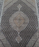 A hand-knotted Persian Tabriz rug with a geometric medallion design in the center, featuring a mix of colors including black, beige, green, brown, blue, and gold.
