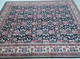 A traditional Persian Varamin rug with a dark navy blue field, featuring a dense floral and vine pattern in red, beige, and light blue, finished with an ornate multi-colored border.