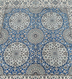 A square-shaped, handmade Persian Nain rug with a geometric floral design featuring light blue, beige, green, pink, and black tones on a fine 9 ply cotton base.