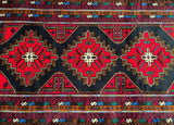 A vintage Afghan Balouchi rug with geometric medallion design, featuring a black, red, blue, and brown color palette.