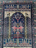 A vintage Afghan Balouchi prayer rug with geometric and floral patterns, predominantly in blue and beige tones, and a semi-geometric design.
