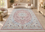 A large traditional Persian Kashmar area rug with a dusty pink, blue, and beige floral pattern, displayed in a bright, modern living room with a curved cream sofa and light wood flooring.