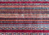 A close-up view of a multicolored geometric patterned Afghan hall runner rug.