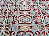 A close-up of a traditional Ziegler Afghan Chobi rug with a floral design in red, beige, terracotta/orange and aqua marine tones, featuring intricate detailing and a revival of the Ziegler pattern.