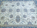 A hand-knotted Afghan Chobi rug featuring a floral design in beige, pink, blue, and green tones on a white background.