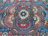 A traditional hand-knotted Afghan Roshnai rug with a geometric medallion design in a colorful pattern, featuring beige, gold, green, and burgundy tones.