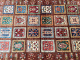 A multicolored hand-knotted Afghan Super Kazak rug with a geometric pattern, featuring various colors such as blue, red, green, and beige, woven on a cotton base.