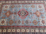 A certified handmade Afghan Super Kazak rug with a geometric design, featuring a combination of blue and red colors and intricate patterns.