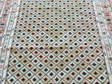 A close-up of an Afghan Mishwani tapestry rug featuring a geometric pattern in pastel and vibrant colors.